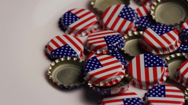 Tiro giratorio de tapas de botellas con la bandera estadounidense impresa en ellas — Vídeos de Stock