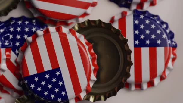 Tiro giratorio de tapas de botellas con la bandera estadounidense impresa en ellas — Vídeos de Stock