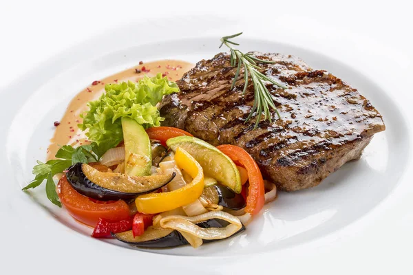 Filete de cerdo con guarnición vegetal. En un plato blanco —  Fotos de Stock