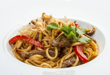 Beyaz plaka üzerinde Udon noodle ile Dana eti