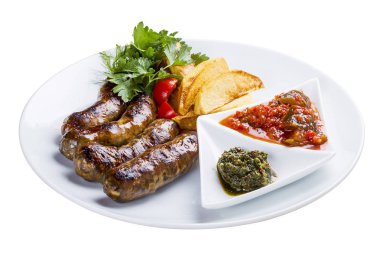 Patates ve sos ile ev yapımı sosis. Beyaz bir plaka üzerinde