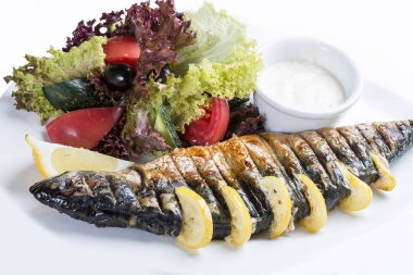 Limon ile pişmiş uskumru. Beyaz bir plaka üzerinde