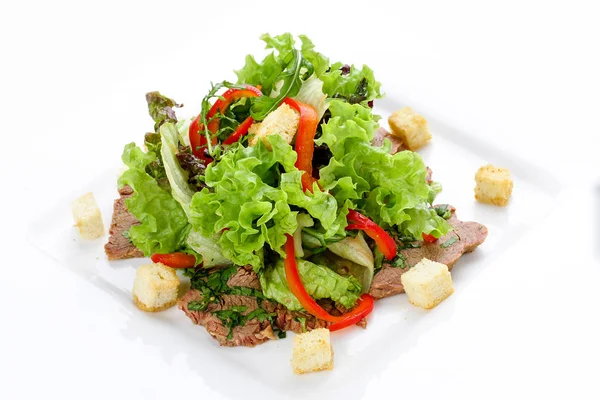 Салат с телятиной и овощами на белой тарелке — стоковое фото
