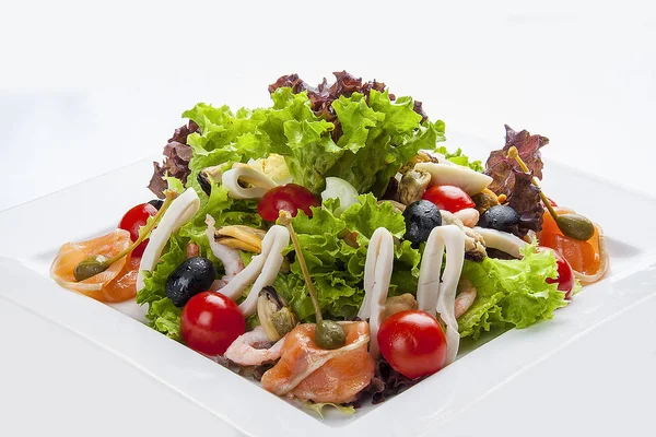 Ensalada con salmón y marisco en un plato blanco —  Fotos de Stock