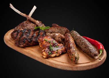 Ahşap bir tahta üzerinde çeşitli kızarmış et.