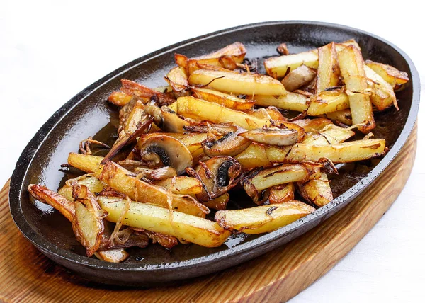 Batatas fritas com cebolas e cogumelos. Em uma frigideira de ferro fundido . — Fotografia de Stock