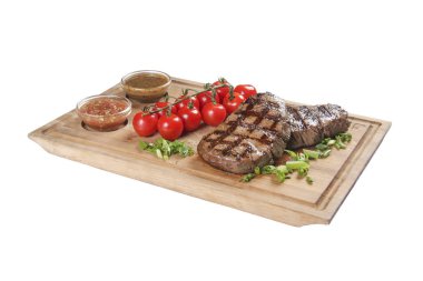 Soslu ve yeşillikli domuz bifteği. Beyaz tahta ve beyaz arka plan üzerinde.