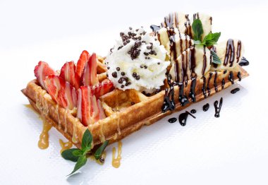 Beyaz arka planda Belçika tatlı waffle'ları. Çilek, muz ve krem şanti ile doldurulmuş