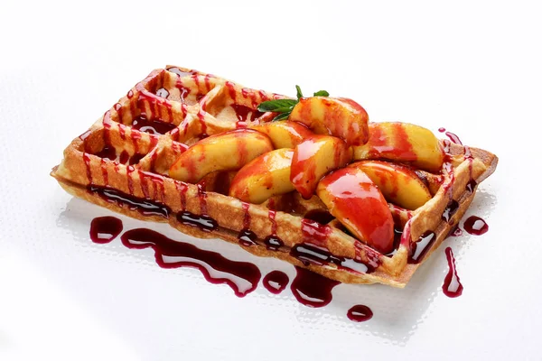 Belgas waffles doces em um fundo branco. Cheio de pêssegos e xarope — Fotografia de Stock