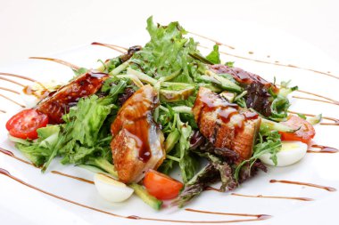 Beyaz arka planda füme yılan balığı ile salata