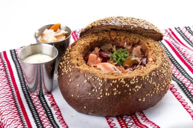 Borsch. Mantar ve fasulye ile bir ekmek tenceresinde. Vejetaryen yemek. Beyaz arka planda.