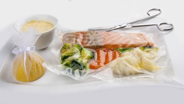 Somon beyaz bir arka plan üzerinde sebze ile sous vide pişmiş
