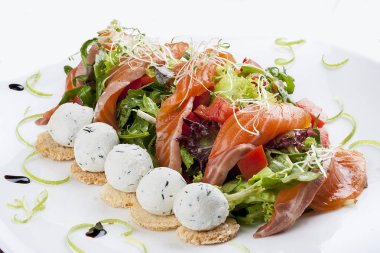 Beyaz bir backgr üzerinde somon ve süzme peynir topları ile salata