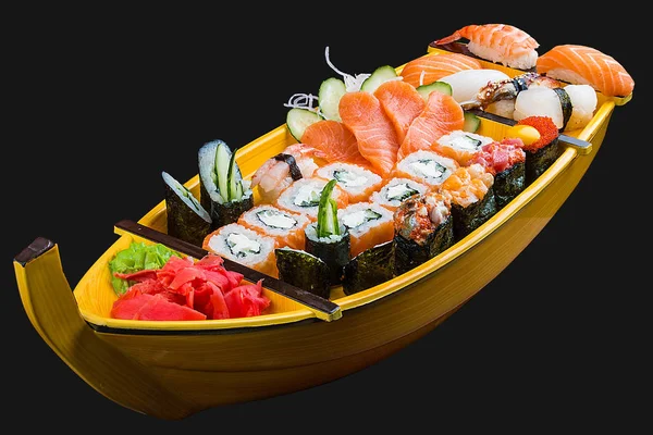 Sushi szett egy fából készült hajón fekete alapon — Stock Fotó