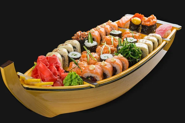 Sushi szett egy fából készült hajón fekete alapon — Stock Fotó