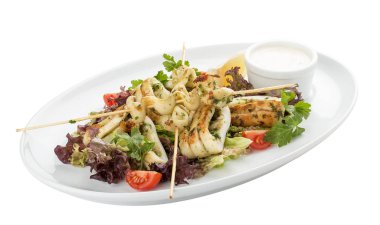 Şişlerde ızgarada salata ve soslu kalamar. Beyaz arka planda