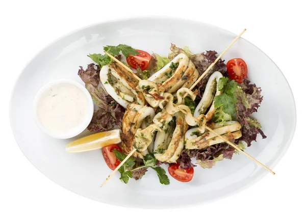 Şişlerde ızgarada salata ve soslu kalamar. Beyaz arka planda