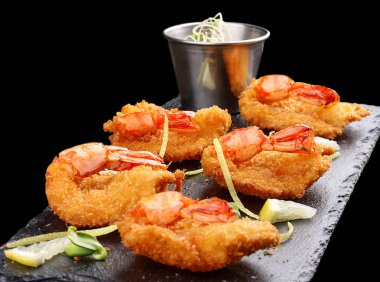 Batter içinde kaplan karidesleri. Siyah arka planda baharatlı sos ile Ebi tempura