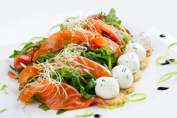 Beyaz arka planda somon ve süzme peynir topları ile salata