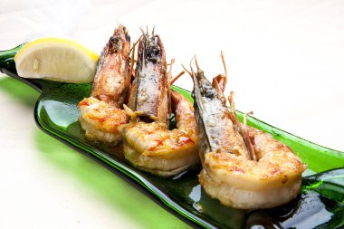 Beyaz arka planda şarap soslu Kral karidesleri