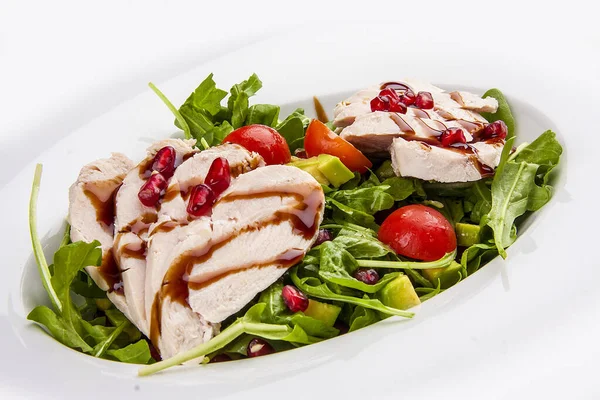 Salad with chicken with pomegranate sauce on a white background