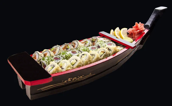 Sushi szett egy fából készült hajón fekete alapon — Stock Fotó