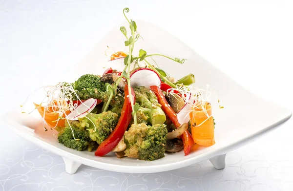 Ensalada vegetal de primavera. Pimientos, zanahorias, brócoli y rábanos. Sobre fondo blanco —  Fotos de Stock