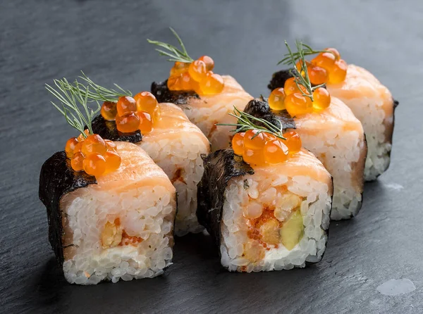 Sushi rolka s lososem a kaviárem na černém pozadí — Stock fotografie