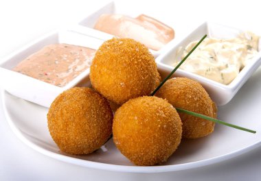 Beyaz arka planda soslu kızarmış peynir topları.