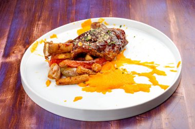 Yarı cam soslu kuzu incik, karamelize sebzeli havuç püresi.