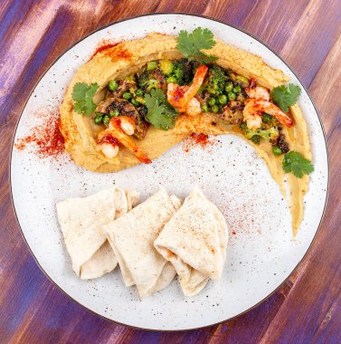 Karides, brokoli, kabak, patlıcan, bezelye ve ev yapımı tortilla ile humus.