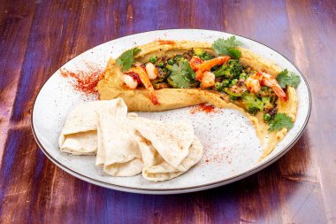 Karides, brokoli, kabak, patlıcan, bezelye ve ev yapımı tortilla ile humus.