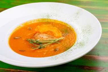 Tofulu kabak kremalı çorba. Renkli ahşap bir arka planda. Vejetaryen yemeği..