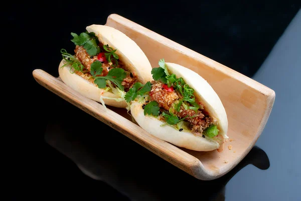 Bao. Steamed rice rolls with shrimp and herbs.  On a black background. Vegetarian dish.