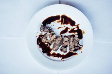 Bir plaka üzerinde sos ile kızarmış et dilimleri