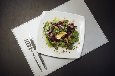 Masada bir plaka üzerinde karidesler ve yeşillikler ile salata
