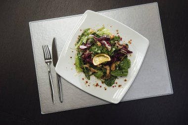 Masada bir plaka üzerinde karidesler ve yeşillikler ile salata