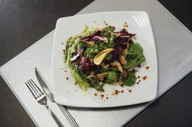 Masada bir plaka üzerinde karidesler ve yeşillikler ile salata