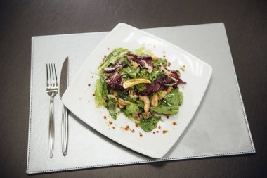 Masada bir plaka üzerinde karidesler ve yeşillikler ile salata