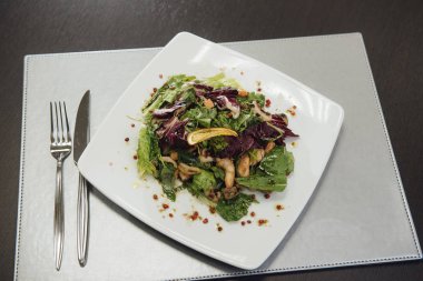 Masada bir plaka üzerinde karidesler ve yeşillikler ile salata