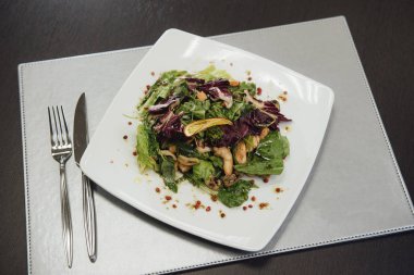Masada bir plaka üzerinde karidesler ve yeşillikler ile salata