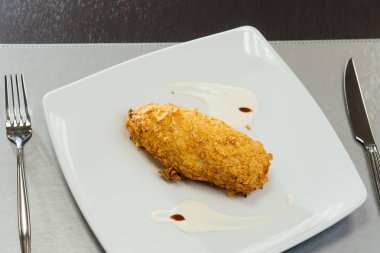 Masada bir tabak üzerinde tavuk göğsü