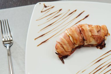 Masada beyaz bir plaka üzerinde kızarmış pastırma ile et