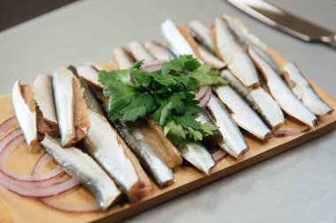 masada bir kesme tahtasında Yeşiller ile taze Sprat