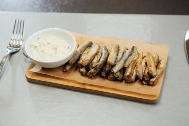 masada bir kesme tahtasında sos ile Sprat