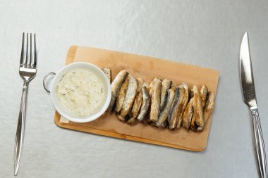 masada bir kesme tahtasında sos ile Sprat