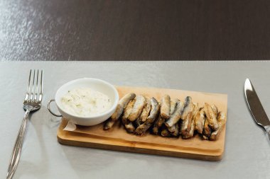 masada bir kesme tahtasında sos ile Sprat