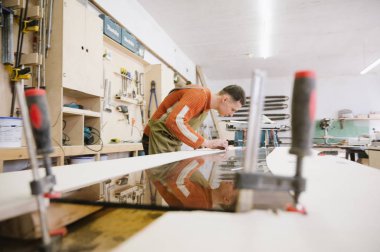 Master maranyesiye atölyesinde bir yüzey taşlama makinesi üzerinde çalışır