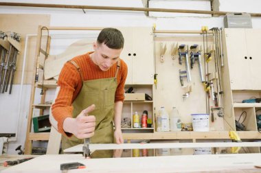 Master maranyesiye atölyesinde bir yüzey taşlama makinesi üzerinde çalışır