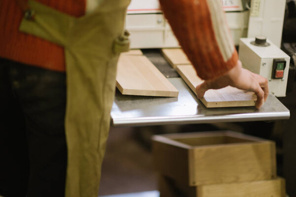 The master works on a surface grinding machine in the carpentry workshop